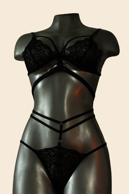 Conjunto de lencería de encaje strappy con tiras tipo arnés, color negro, vista frontal (bra y tanga) - Lunatik